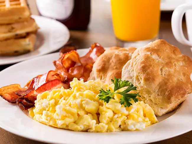 plates of eggs, bacon and biscuits